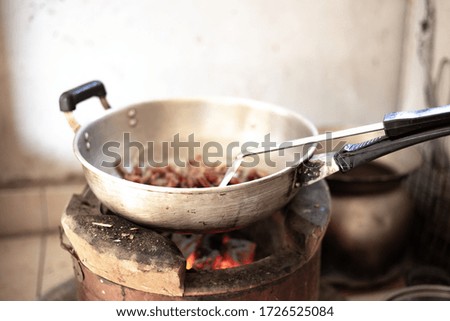 Blurred picture of stainless steel pan on stove, cooking in countryside kitchen.