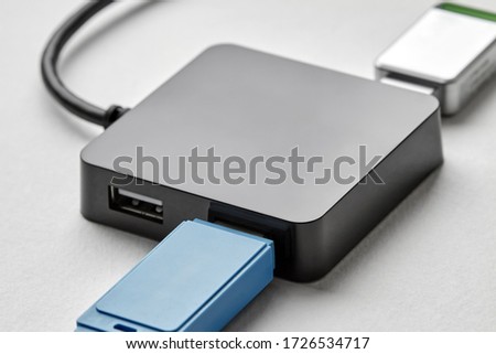 Black portable USB hub for four connections with usb flash drives on a white background. Bus povered. Closeup, selective focus