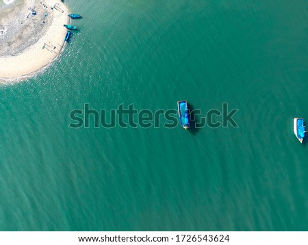 an aerial shot of a boat in a sea