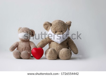 Toy bear in the mask with red heart, Teddy bear wearing face mask protective for spreading of disease virus CoV-2 Coronavirus Disease 2019 quarantine and outbreak alert sign concept. 