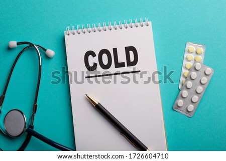 Stethoscope and wooden cubes, top view, blue background, COLD