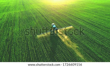 Tractor spray fertilizer on green field drone high angle view, agriculture background concept. Royalty-Free Stock Photo #1726609156