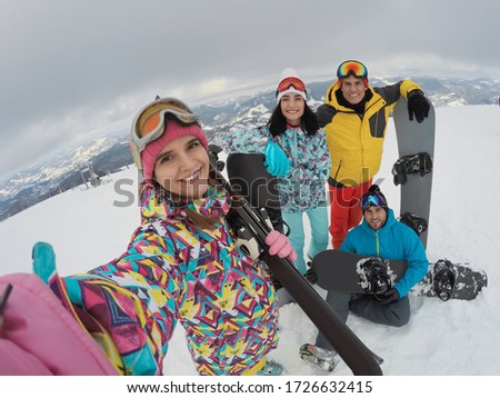 Group of friends with equipment taking selfie at ski resort. Winter vacation