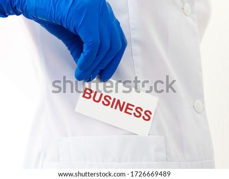 BUSINESS word on paper card in doctor's hand. Business and medicine concept