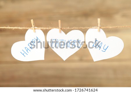 Happy Fathers Day written on paper hearts on grey background. Top view