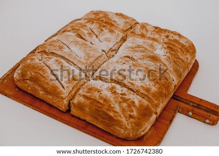 Eight pieces of fresh baked bread on a wooden plank