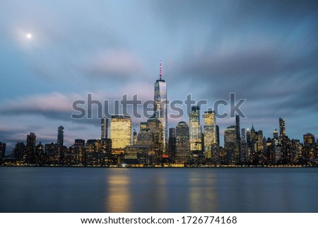 Cityscape photo of New York at night with full moon.