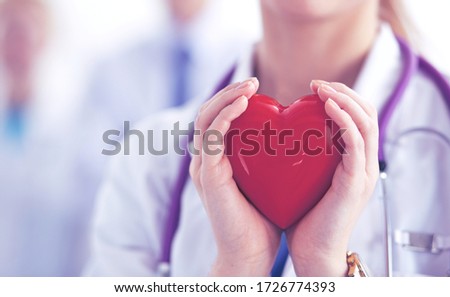 Female doctor with stethoscope holding heart