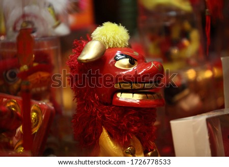 Traditional toy sculpture of Chinese red ox (bull) showing teeth (at year of bow) at exposure in street market of Hong Kong city at night. 