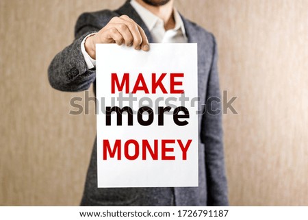Man holding a sheet of paper with the text Make more money on white background