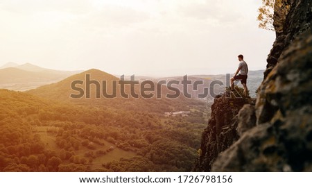 A man standing on top of a mountain as the sun sets. Goals and achievements concept photo composite. Concept vision, Hiker looking mountain and enjoying sunrise