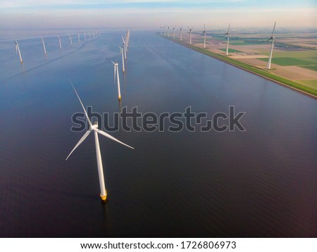 close view with drone at windmill park in the lake Ijsselmeer in the netherlands Noordoostpolder, Windmill turbines from above in Europe producing green energy