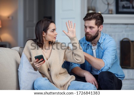 Modern couple at home. Man and woman concentrated on messaging with smartphones, ignoring each other and spending time on social media. Royalty-Free Stock Photo #1726841383