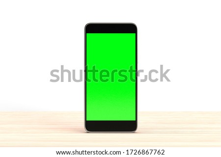 Phone mock up template chroma key green screen. Mobile phone on wood table surface isolated on white background. Smartphone digital device. Cellphone with blank screen display. Touch screen device.