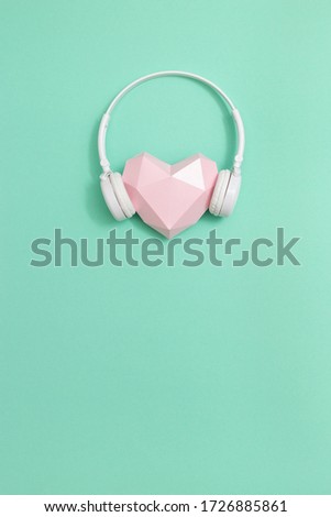 3d pink paper heart in white headphones. Concept for music festivals, radio stations, music lovers.  Live with music. Minimal style. Copy space.