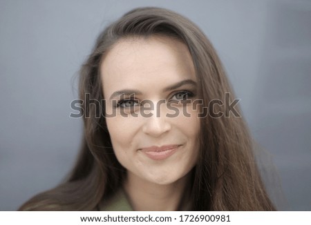 A picture of a beautiful smiling  woman with mesmerizing green eyes against a blurry background