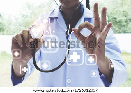 Doctor using stethoscope with icon medical and modern virtual screen interface, medical technology network concept.