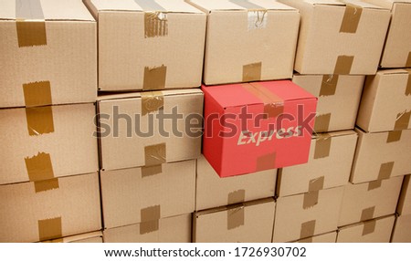 Cardboard boxes for express delivery or moving. One box is special and taken out. Stack of boxes and blue background