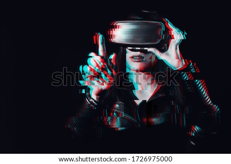 girl wearing virtual reality glasses touches an imaginary projection screen with her finger. Black and white with 3D glitch effect