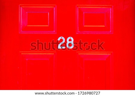 House number 28 on a red wooden front door