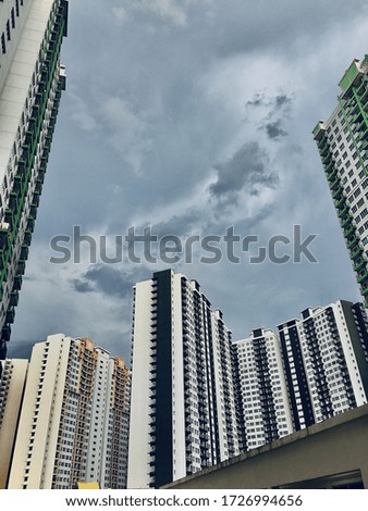 A low angle shot of high buildings and a cloudy sky