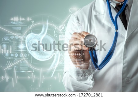 Doctor against the background of a hologram of the stomach, endoscopy procedure. Digestive tract and stomach disease concept. Mixed medium, copy space Royalty-Free Stock Photo #1727012881