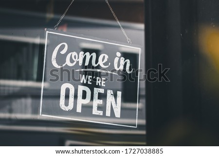 Come in we're open, vintage black retro sign in glass door storefront Royalty-Free Stock Photo #1727038885