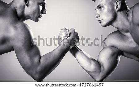 Hand wrestling, compete. Hands or arms of man. Muscular hand. Clasped arm wrestling. Two men arm wrestling. Rivalry, closeup of male arm wrestling. Two hands. Muscular men measuring forces, arms.