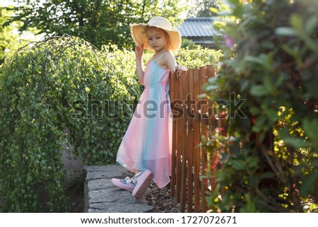portrait of a little girl in a hat in the garden