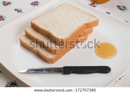 image of some slaces of bread and a glass of honey