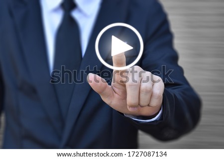 Businessman pressing play button to start. Idea for business, technology, and presentation. Royalty-Free Stock Photo #1727087134