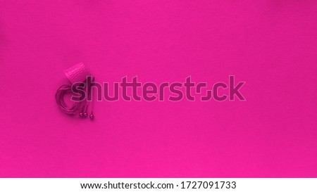 Thimble, thread and safety pin on pink background. Monochrome simple flat lay with pastel texture. Fashion eco concept. Stock photography.