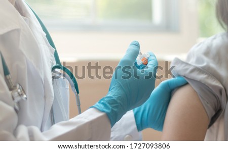 World immunization week and International HPV awareness day concept. Teenager woman having vaccination for influenza or flu shot or HPV prevention vaccine with syringe by nurse or medical officer.  Royalty-Free Stock Photo #1727093806
