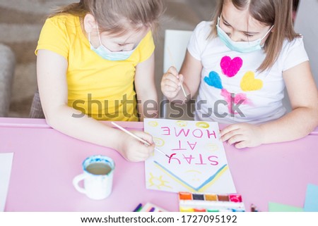 Health safety concept. Girls drawing together at home during quarantine in sterile masks. Childhood games, drawing arts, stay at home concept	