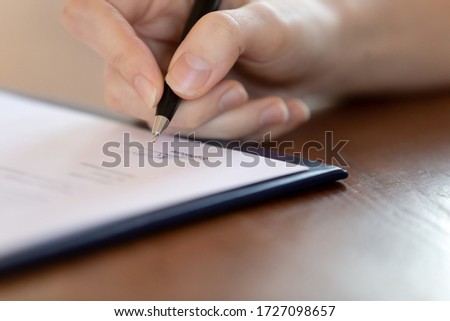 Close up of female patient put signature on paper document make health insurance agreement in hospital, woman client sign paperwork contract, close deal at consultation, healthcare concept