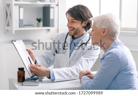 Defeated disease. Happy doctor showing positive test results to senior woman patient at hospital, free space Royalty-Free Stock Photo #1727099989