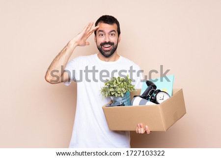 Man holding a box and moving in new home over isolated background has just realized something and has intending the solution