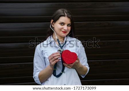 Doctor woman with stethoscope examining red heart
