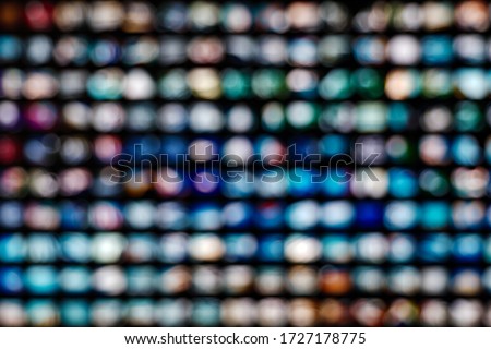 Blurred colorful LED illuminated bokeh background on Grid frame arrangement system. Abstract defocused illuminated backdrop with light bokeh on rectangular grid pattern dispaly.