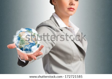 businesswoman holds up a planet Earth. Elements of this image furnished by NASA