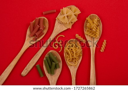 Few pasta grouped by its types in some small wooden spoons.