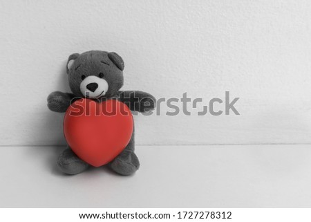 Mini bear doll hugging a red heart on white shelf , selection color red present for picture 