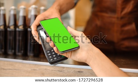 Young Woman is Using Her Smartphone with Green Screen for Contactless Payment. She is Paying for Gourme Street Food. Eco Friendly Gluten Free Food Court Selling Modern Fusion Cuisine