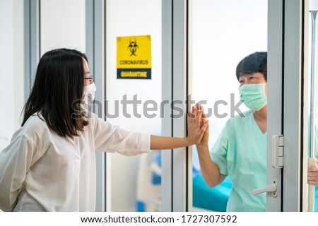 Asian woman come to see her mother a coronavirus patient in virus quarantine room in hospital. coronavirus, self isolation or covid-19 concepts