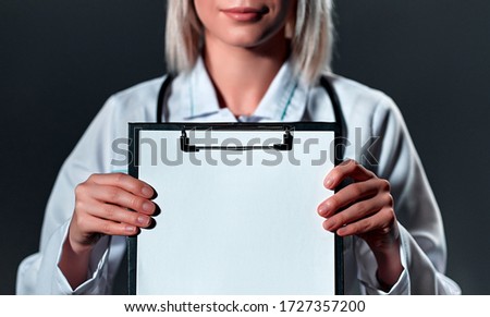 Close up view hands of female doctor holding clipboard with white sheet paper for demonstration isolated.