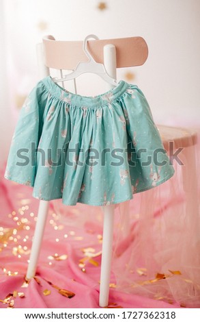 
Stock Photo - Child skirt on hanger on pink background 