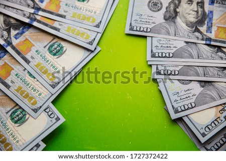 Stack of hundreds of dollars on bright green background with copy space