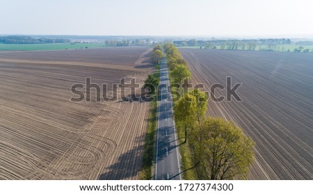 Country road between fields from the air, Germany