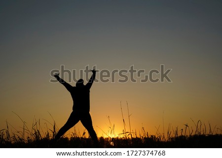Man Jumping in Sun Rays. man in silhouette against the sunset jumping and having fun. happiness and freedom concept for people enjoy the outdoor leisure activity