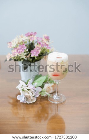 homemade yogurt smoothie and jelly in glass goblet with flowers.focus around front of picture-image.